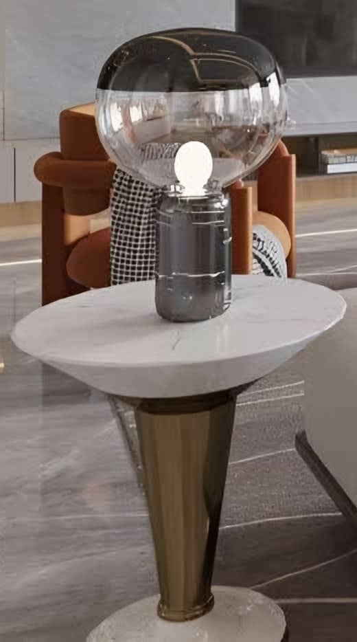 Smoked glass table lamp on a marble-topped side table with a bronze-tone base