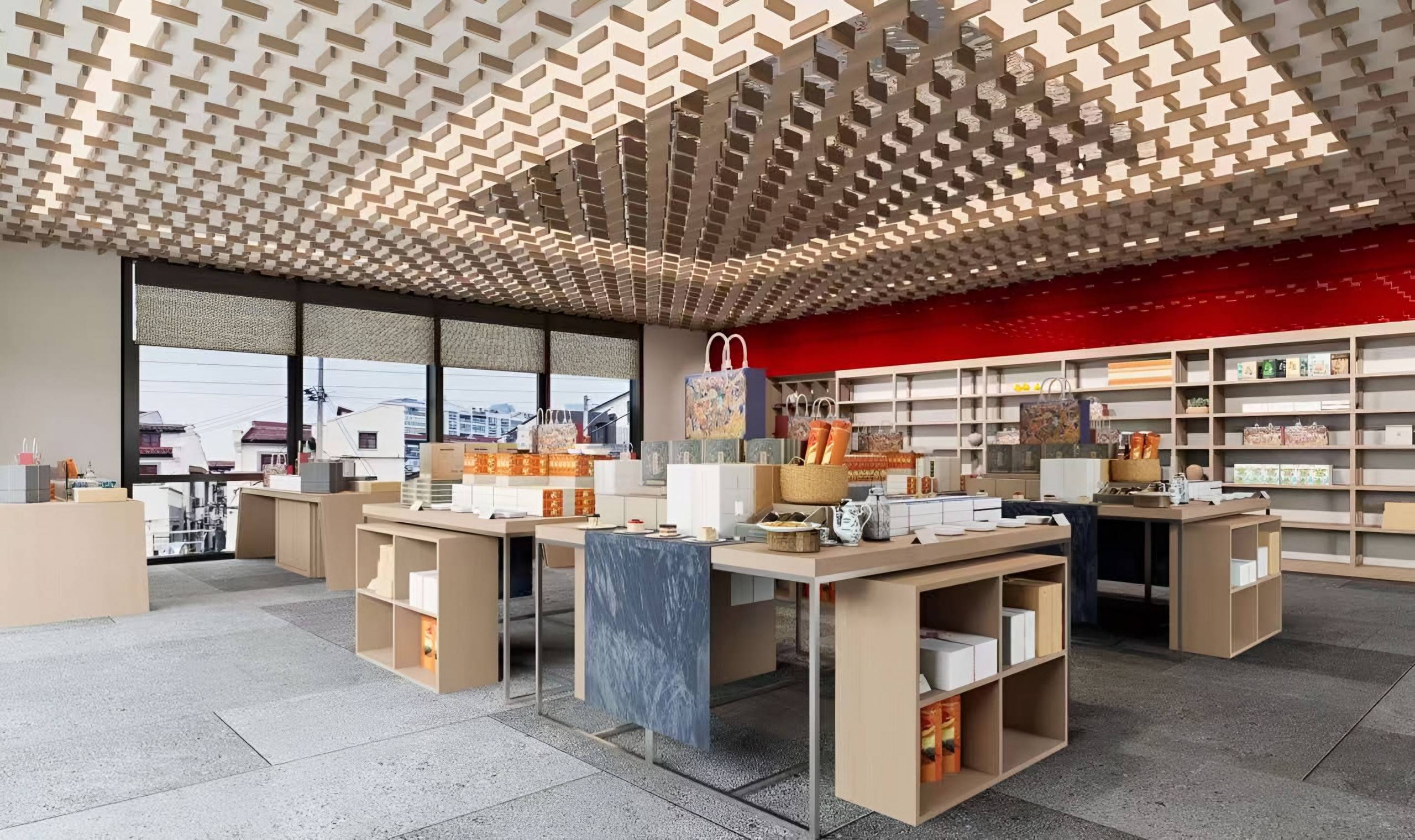 Bookshop and lifestyle store with a sculptural lattice ceiling, timber display tables and a red feature wall