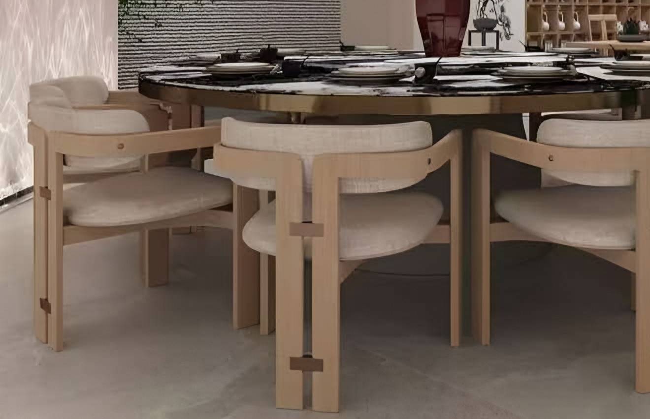 Timber dining chairs with upholstered seats around a round stone table
