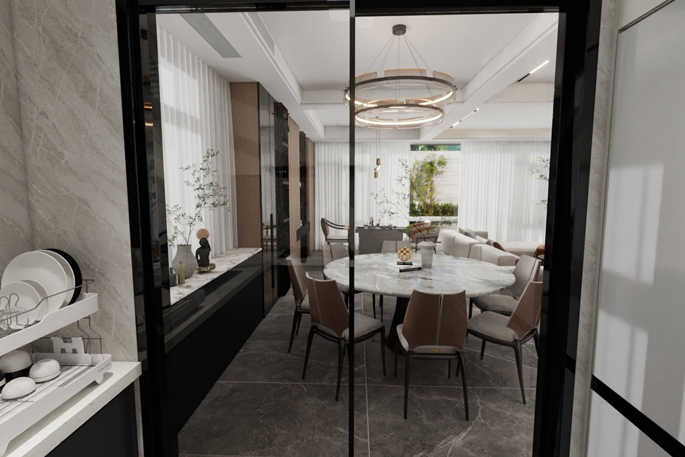 View from the kitchen through a dark-framed glass door to the dining room and ring pendant