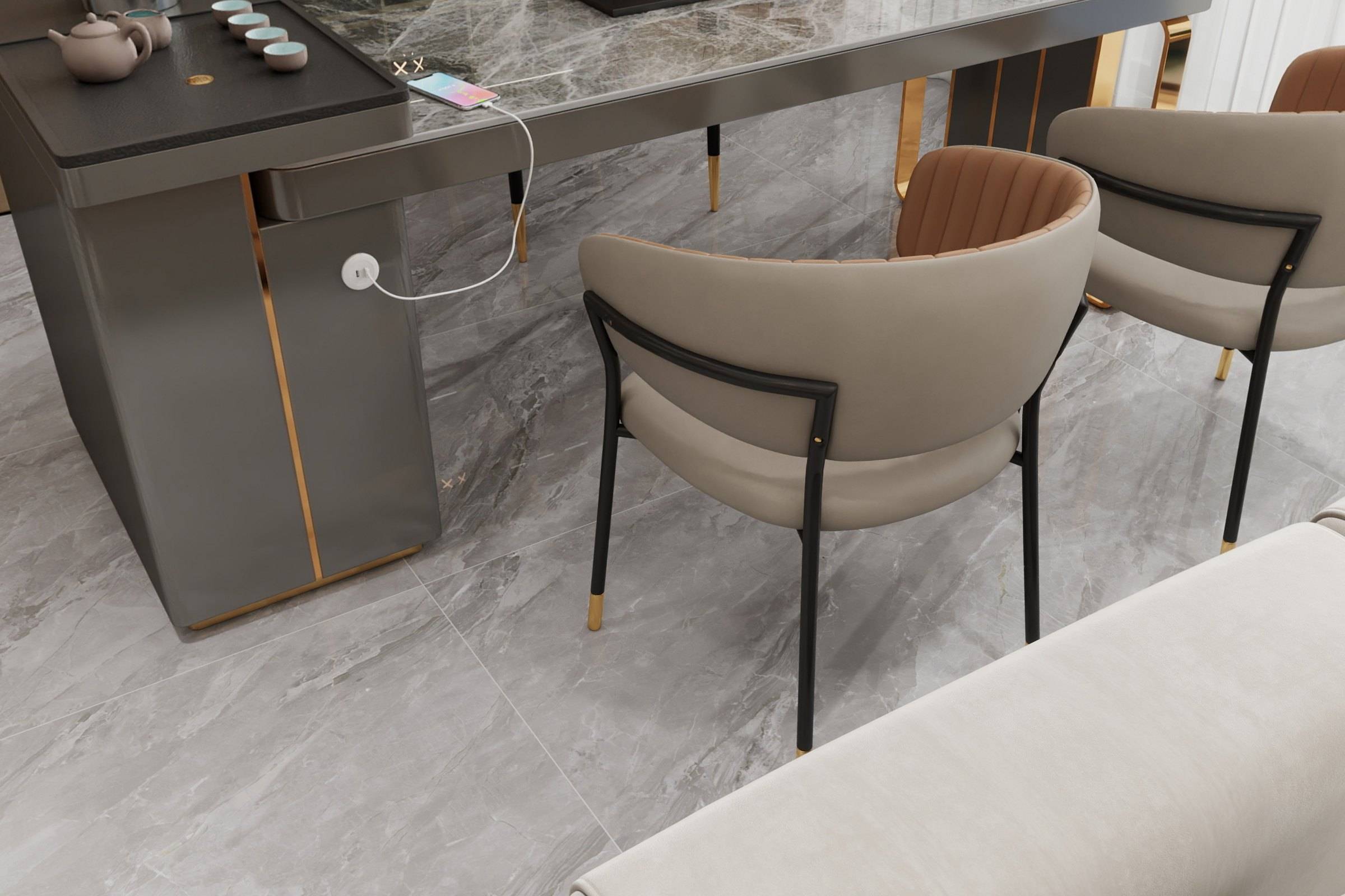 Stone-topped island table in graphite with bronze-tone detailing and curved upholstered chairs