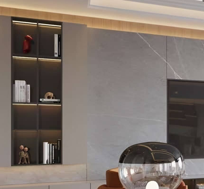 Lit display niche with dark shelving set beside a grey marble wall