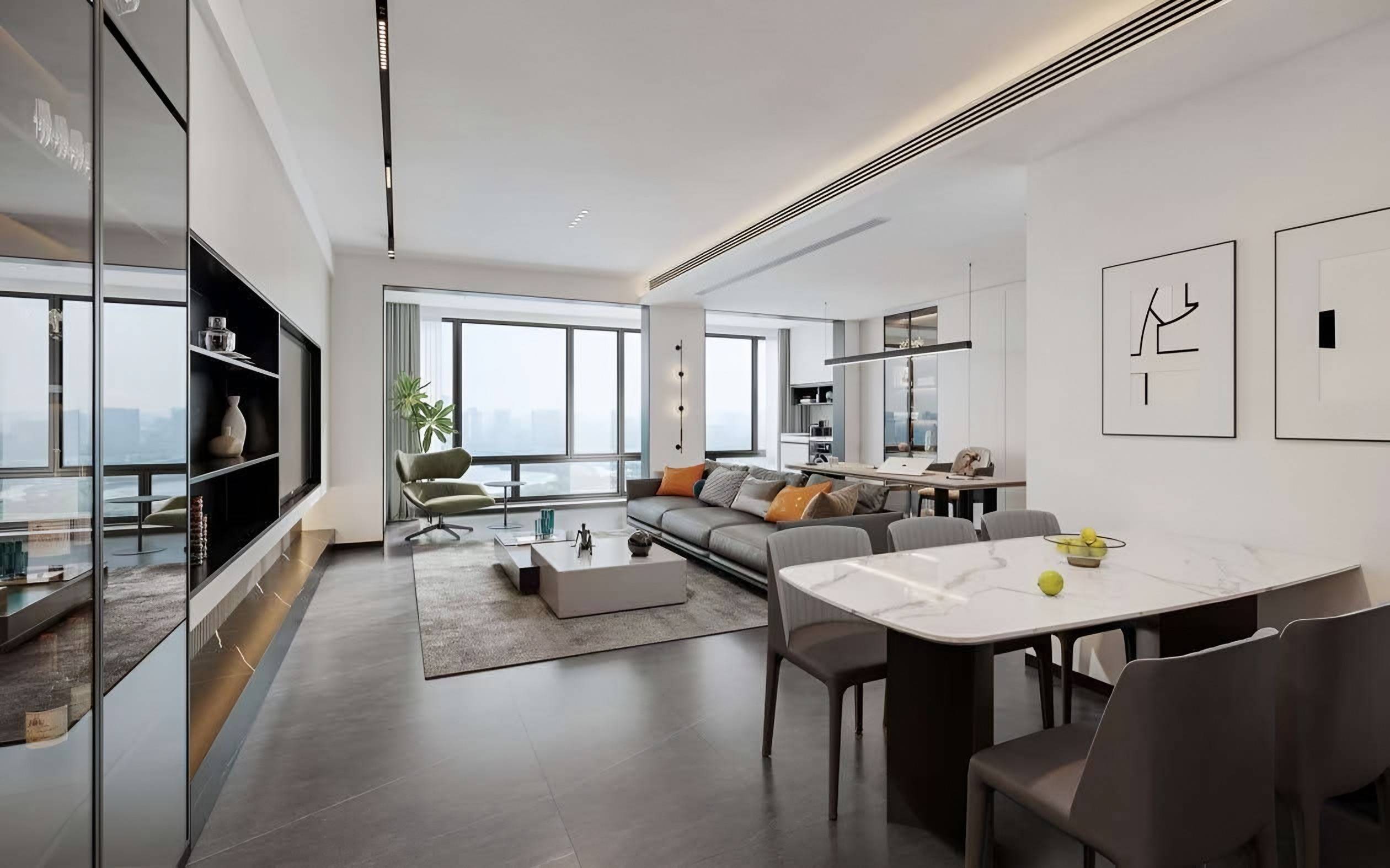 Stone-topped dining table in the foreground with the living room, green lounge chair and city view beyond