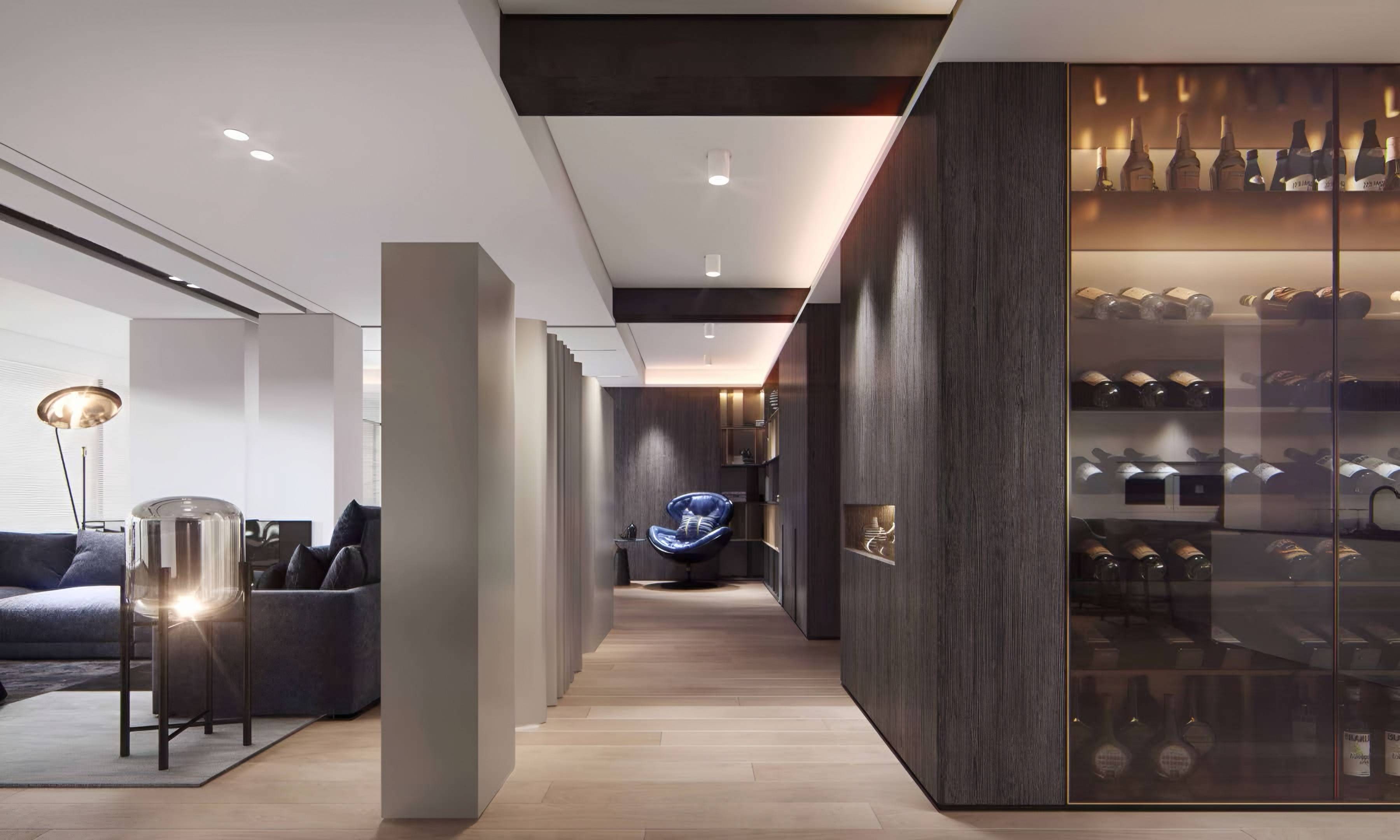 Hallway lined with dark timber cladding and a lit, glass-fronted wine gallery, opening onto the living room
