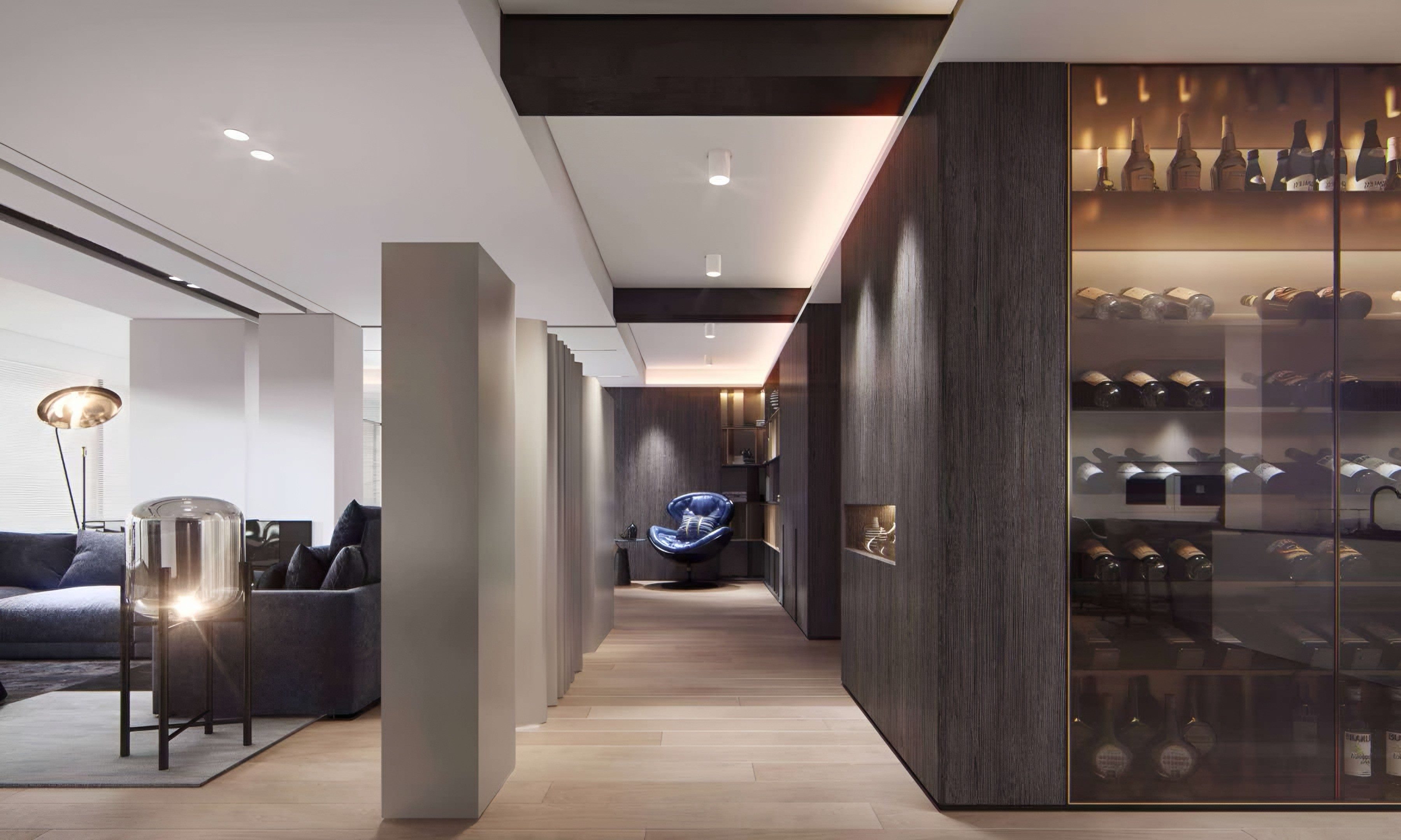 Hallway lined with dark timber cladding and a lit, glass-fronted wine gallery, opening onto the living room