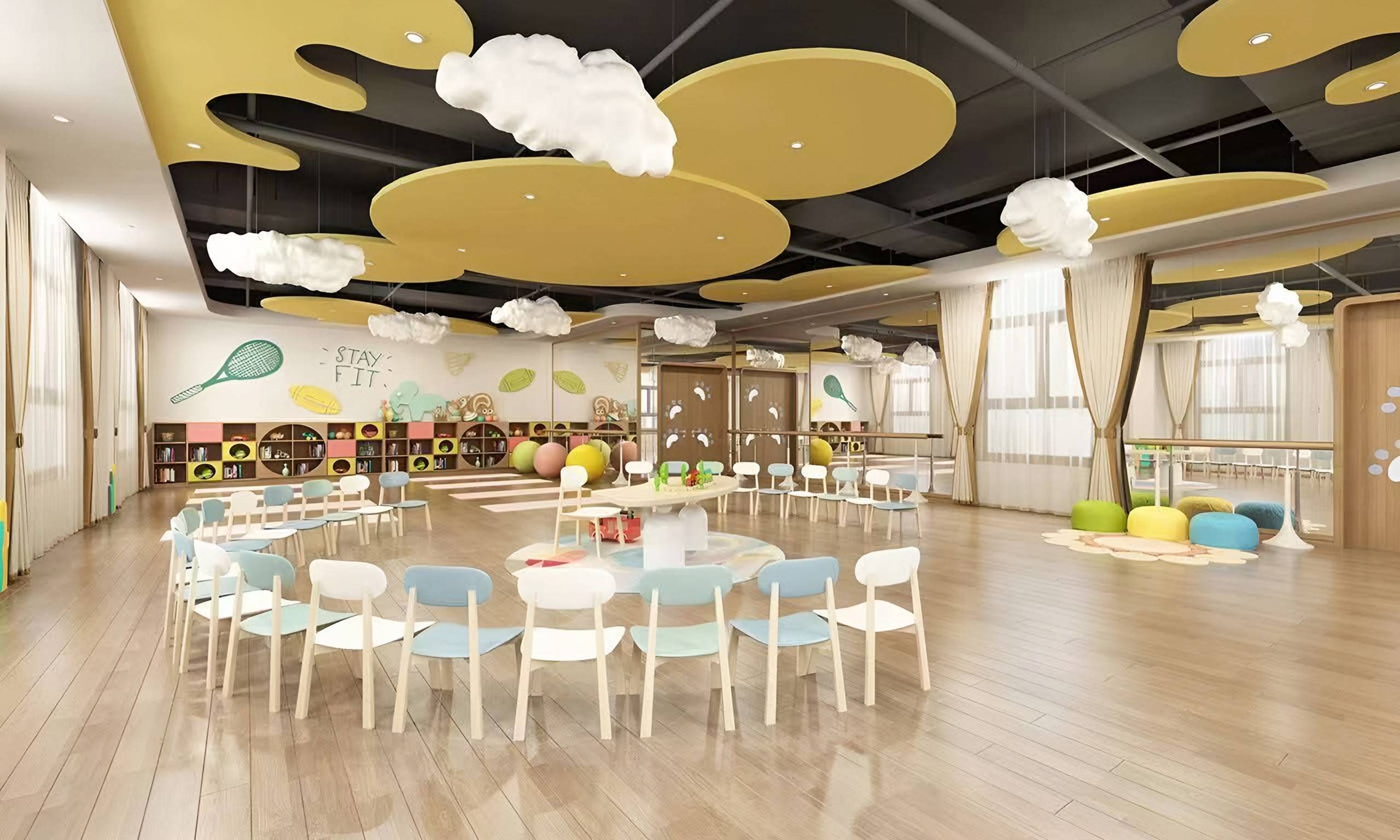 Children's activity hall with suspended cloud forms, curved yellow ceiling panels, timber floor and a ring of small chairs