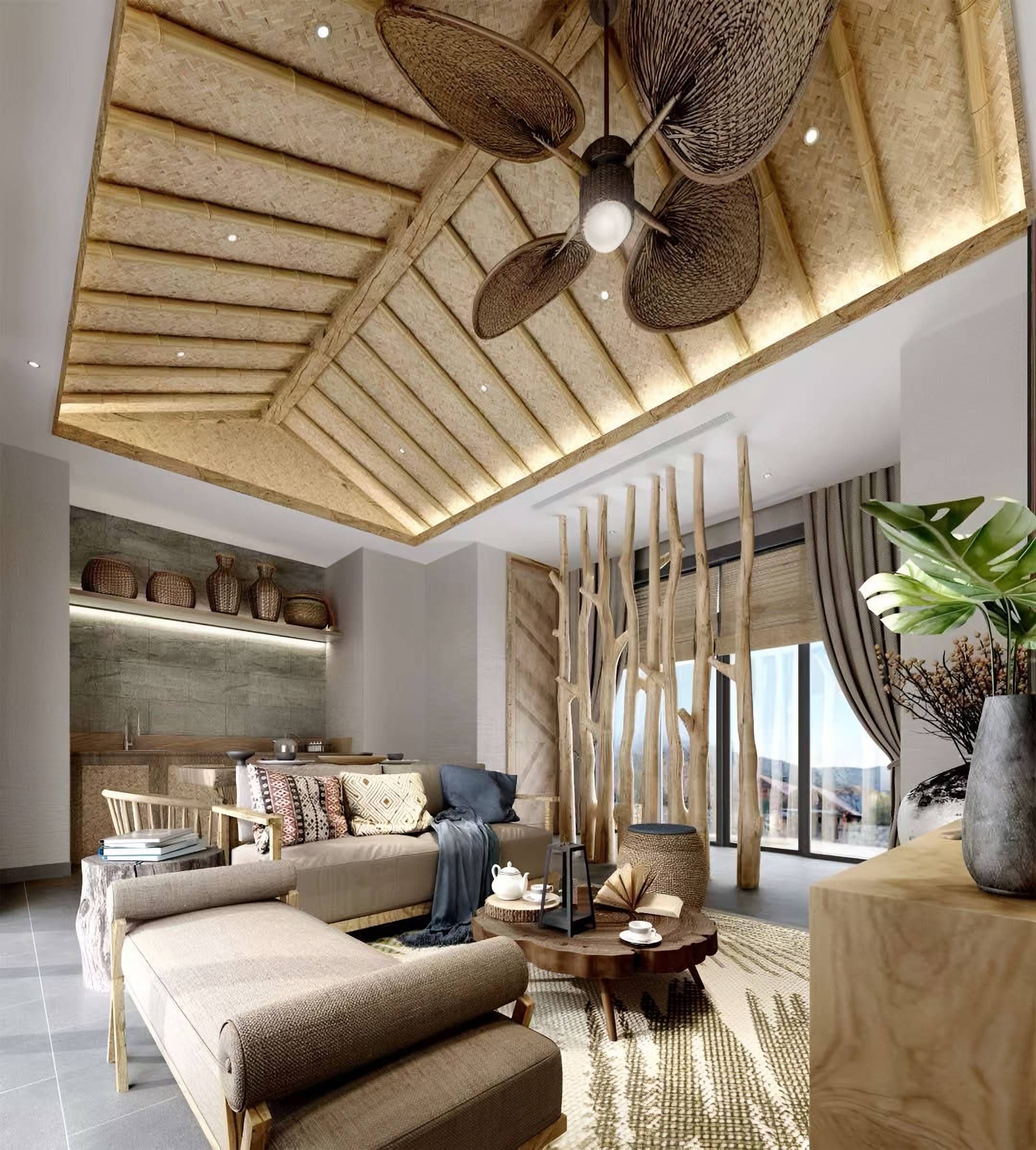 Living room under a woven bamboo ceiling with a timber-framed sofa, a slab coffee table and a screen of natural tree trunks