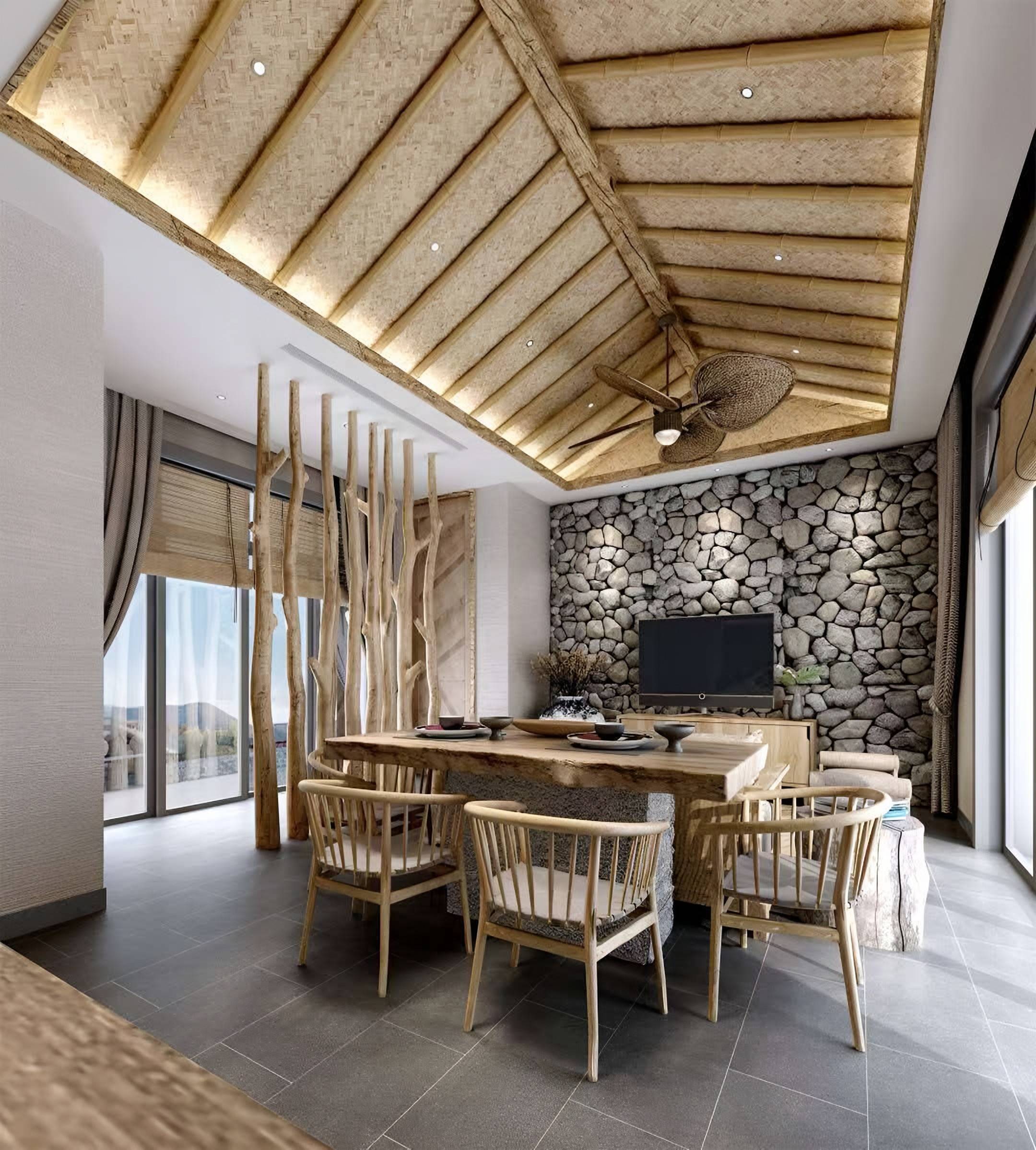 Dining room with a timber slab table, spindle-back chairs, a woven bamboo ceiling and a dry-stone feature wall