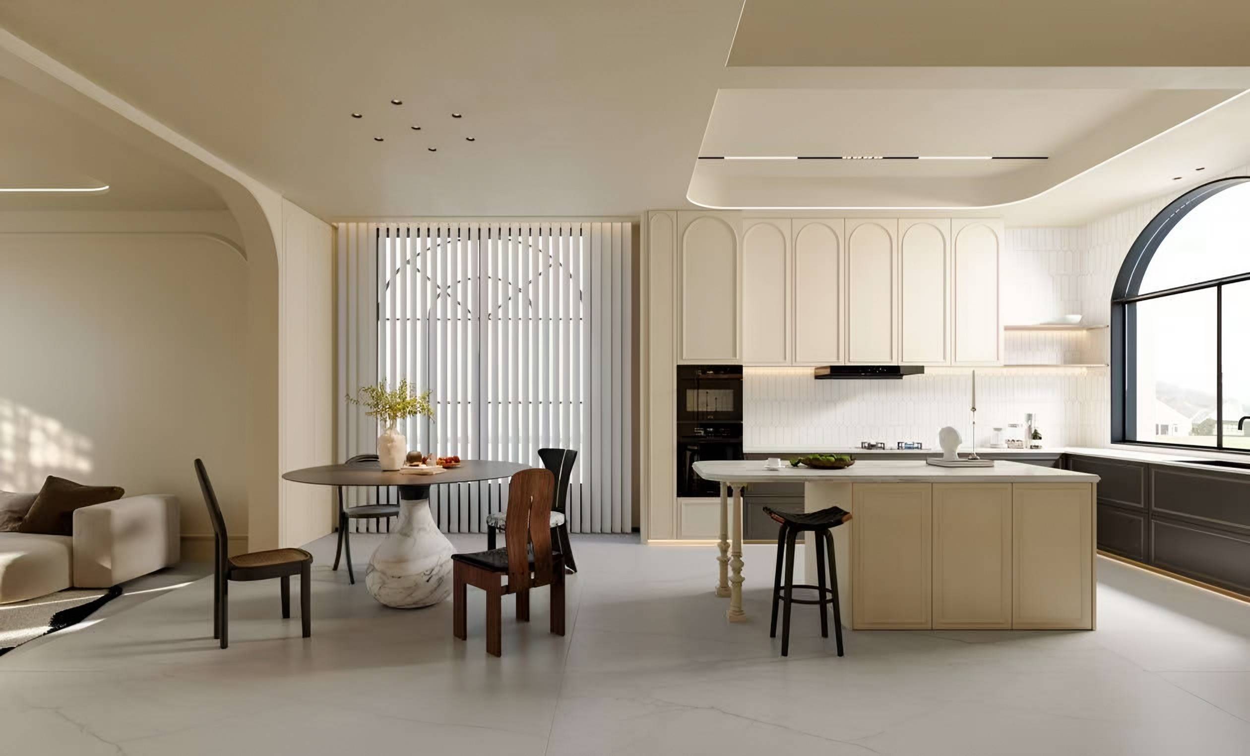 Cream kitchen with arched cabinet doors, a large island, an arched window and a round dining table on a stone pedestal