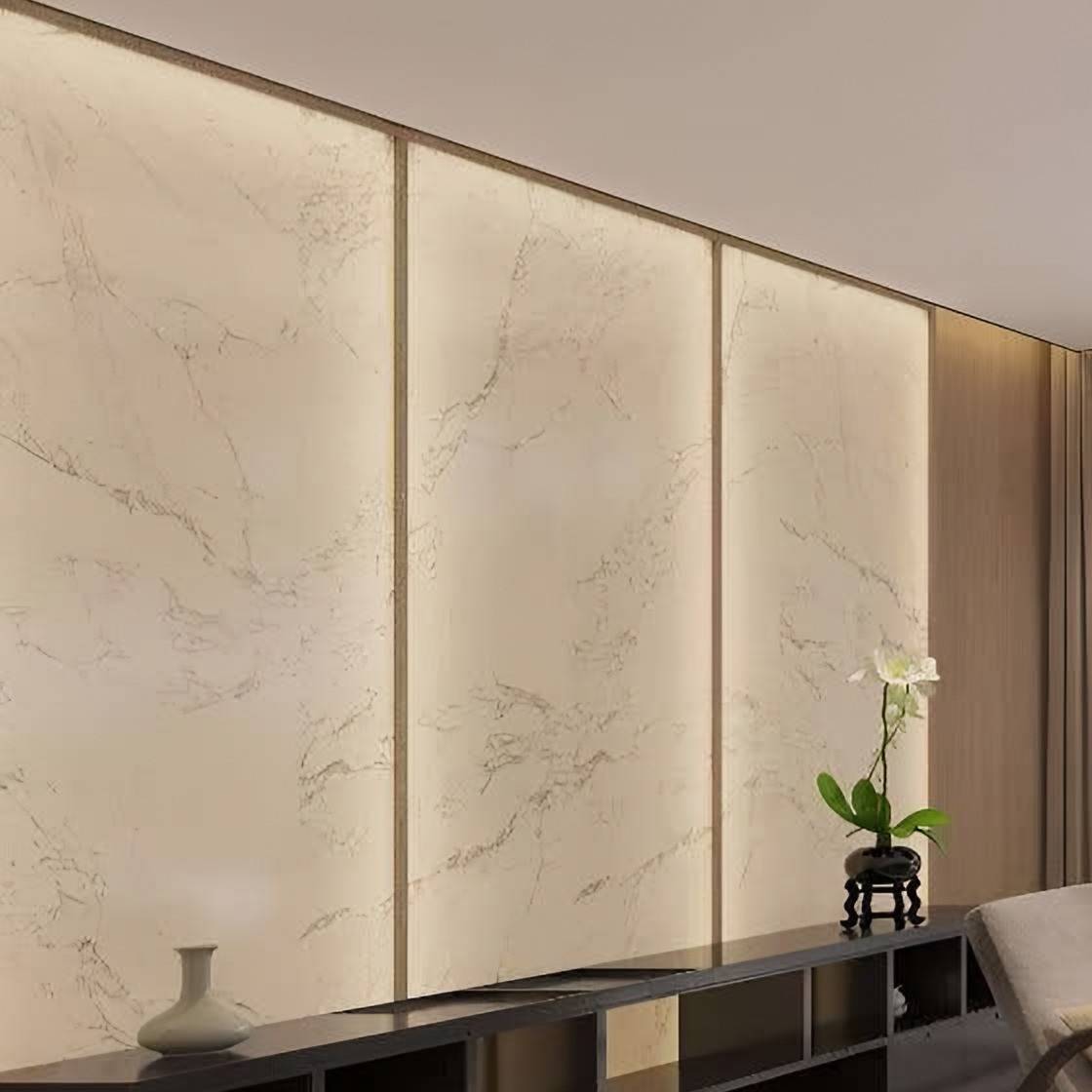 Backlit veined stone wall panels above a low dark timber cabinet