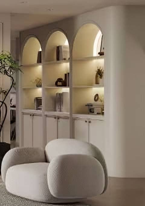 Arched, lit display shelving built into an ivory wall