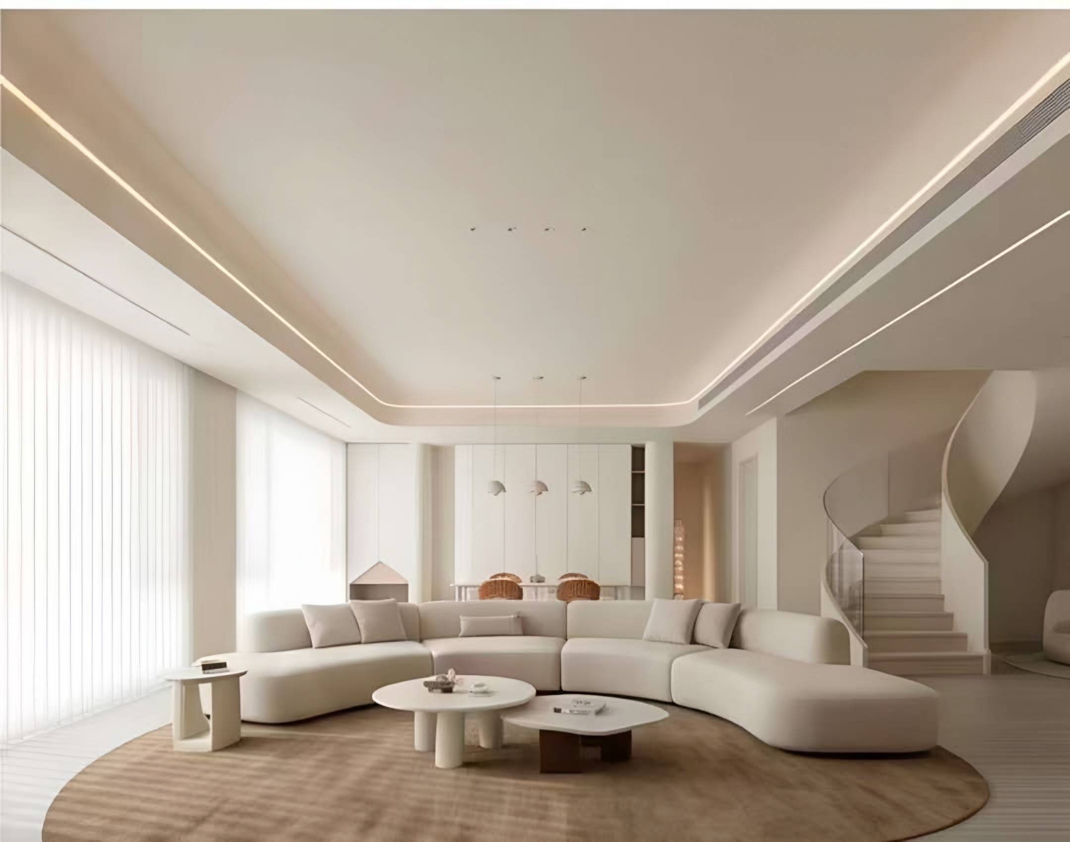 Double-height living room with a long curved sofa, a round rug and a sculpted spiral staircase